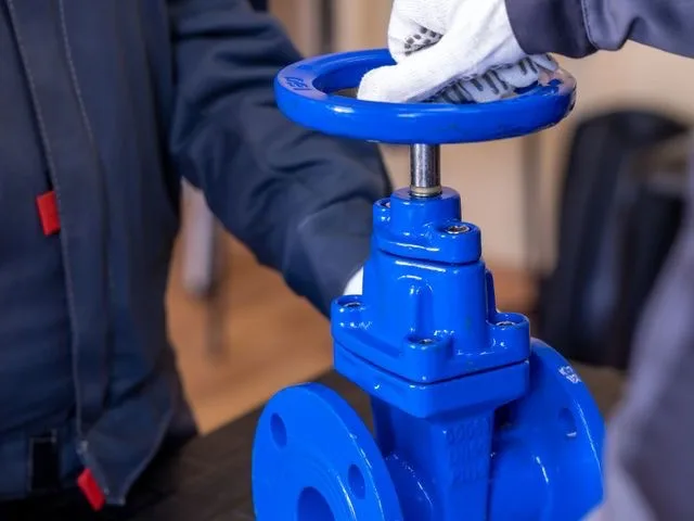 Szakember ipari gázégőt szerel be a kazánházban